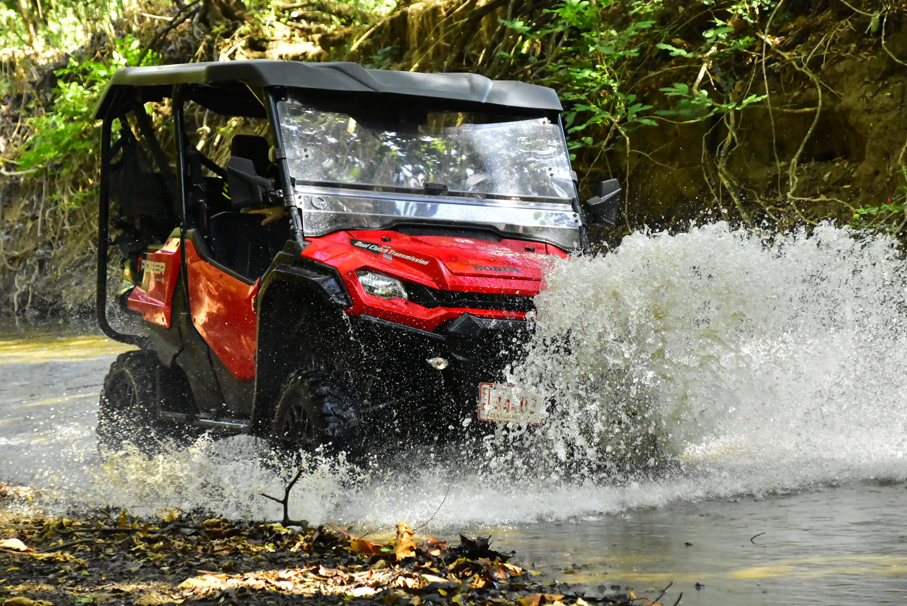 Red UTV splashing through a creek crossing on the Skyline off-road trail