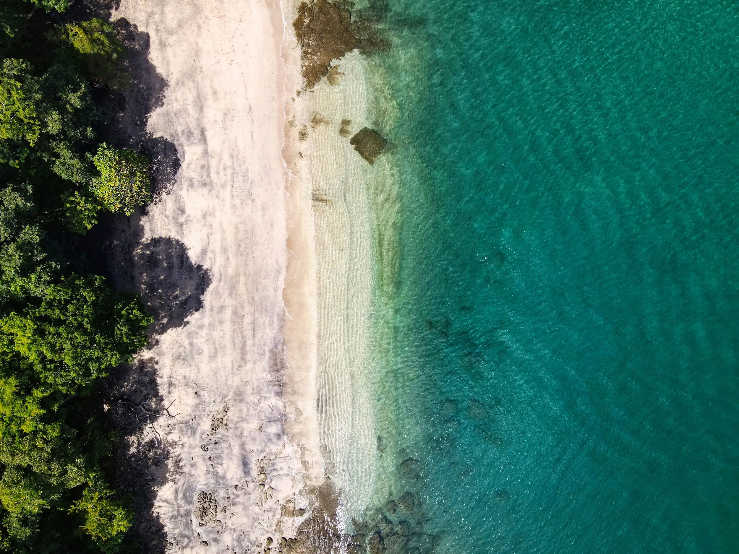 Aerial top-down view of a Guanacaste beach with turquoise water, Costa Rica