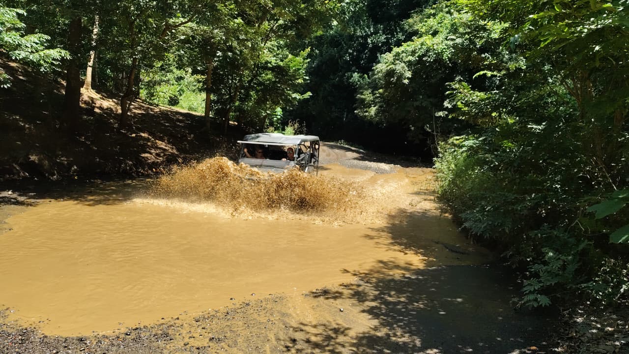 UTV blasting through a mud puddle